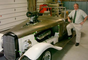 Tim Tarris standing beside a custom hot rod